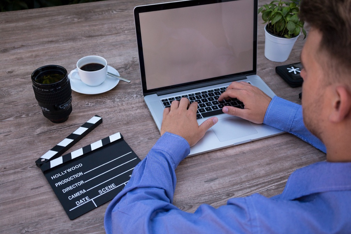 Youtuber editing laptop with screen showing video editing software